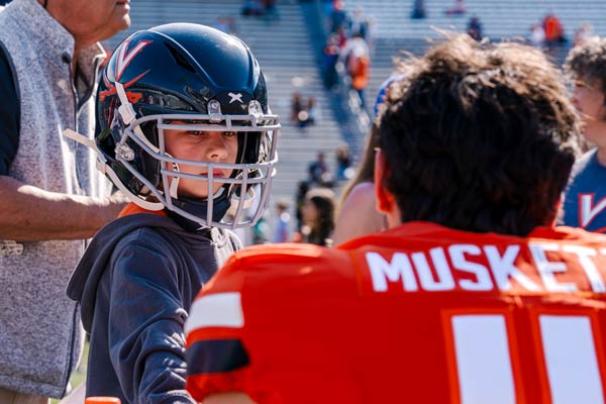 Kid wears player Musket's helmet at spring football game 